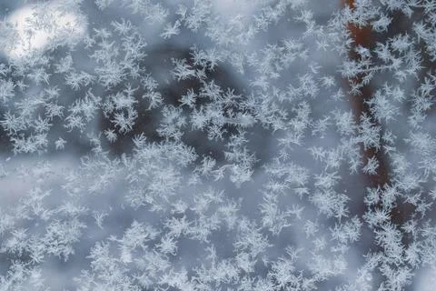 Frost patterns and delicate snow crystals on a glass window pane Stockfoto's