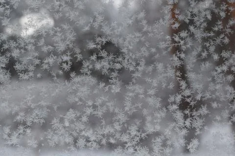 Frost patterns and delicate snow crystals on a glass window pane Stock Photos