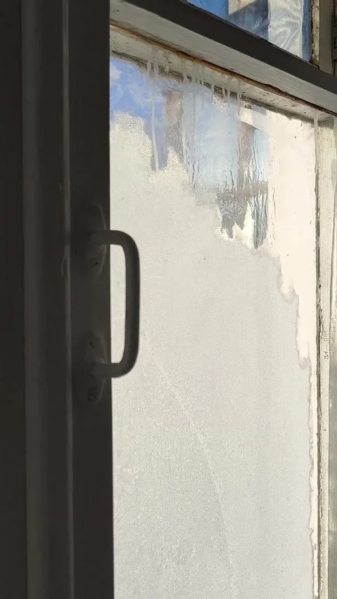 Frost patterns, drops of water and condensation on the glass of an old wooden Stock Footage 326734805