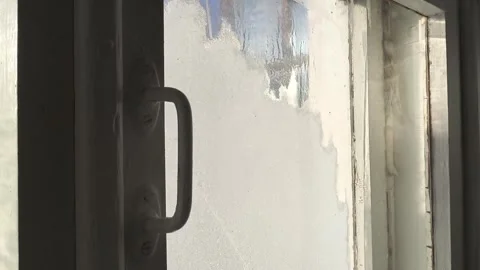 Frost patterns, drops of water and condensation on the glass of an old wooden Stock Footage 326734884
