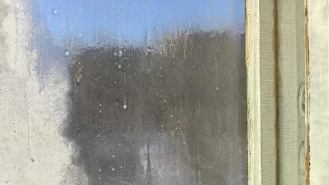 Frost patterns, drops of water and condensation on the glass of an old wooden Stock Footage 326734939