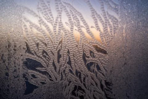 Frost patterns forming on a window glass, creating intricate natural textures Stock Photos