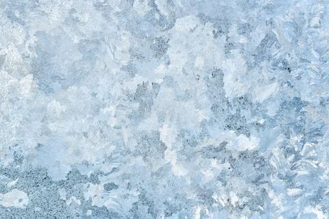 Frost patterns on window glass forming delicate icy textures. Natural winter  Stock Photos