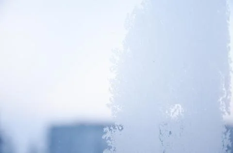 Frost structure on window against the background of sky during winter day. Stock Photos