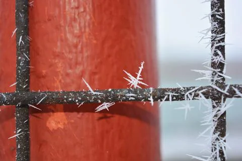 Frost, white snowflakes with sharp corners glued to the dark old metal. 写真素材