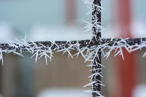 Frost, white snowflakes with sharp corners glued to the dark old metal. Stock Photos