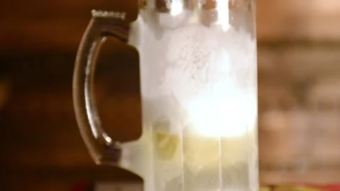 Frosted Cold Beer poured in to mug shot against wooden background 스톡 동영상 145046582