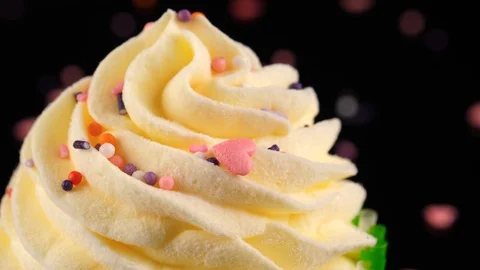 Frosted Cupcake, camera zoom out, black background decorated with sprinkles Stock Footage 91030159