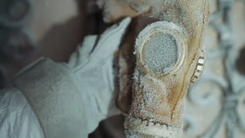 Frosted gasmask held. Silent winter scavenger inspection. Quiet scene with icy Stock Footage 346471316