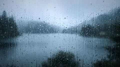 Frosted window glass with raindrops overlooking a misty lake. 4K 스톡 동영상 343244089