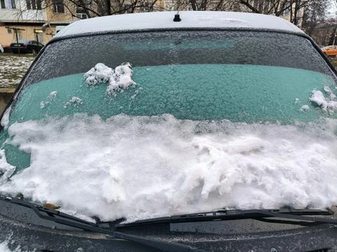 Frosted windshield with a layer of snow creating a textured winter look. Foto stock