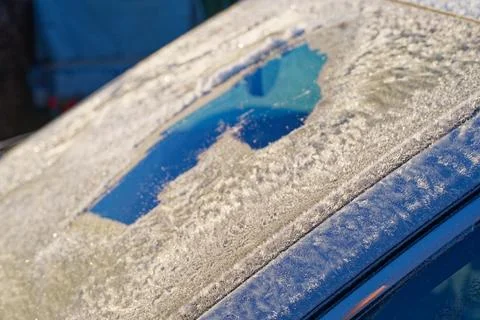 Frosted windshield with tiny cleared hole in winter morning. Stock Photos