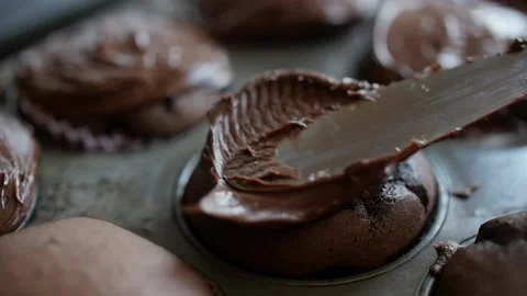 Frosting being placed on chocolate cupcake with knife close up slow motion Stock Footage 150674247