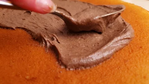 Frosting a sponge cake with chocolate-cocoa paste. Chocolate cream, paste Video stock 313056104