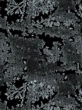 Frostwork pattern ice crystals on black background. Dark surface with abstrac Stock Photos