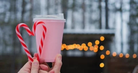 Frosty backdrop frames pink beverage with candy cane heart, revealing romance Stock Footage 301523393