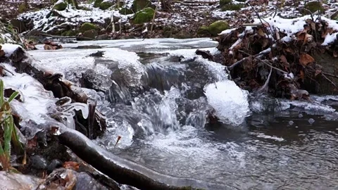 Frosty flowing mountain stream with ice and ice floes in December Stock Footage 166747102
