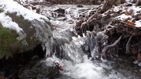 Frosty flowing mountain stream with ice and ice floes in December Stock Footage 166747118