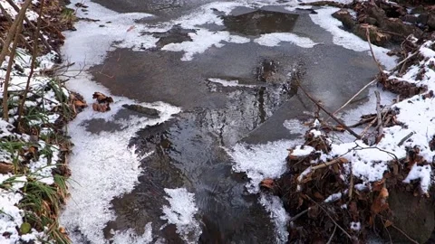Frosty flowing mountain stream with ice and ice floes in December Stock Footage 166749434