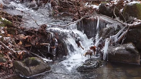 Frosty flowing mountain stream with ice and ice floes in December Stock Footage 166749544