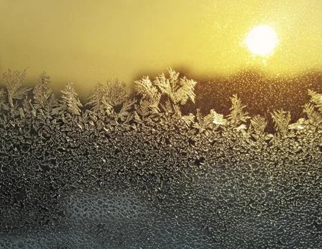 Frosty natural pattern and sun on winter window Stock Photos