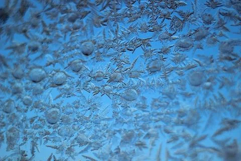 Frosty natural pattern on winter window glass. Natural background. Stock Photos