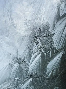 Frosty natural pattern on winter window. Abstract winter background. Stock Photos