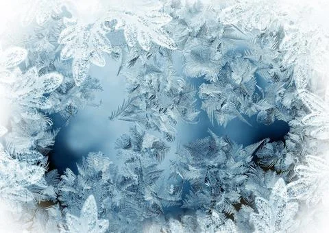 Frosty pattern of white and blue color on the window close-up Stock Photos