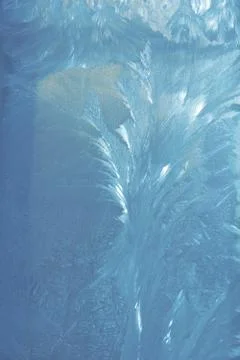 Frosty pattern on the window draws winter blue color Stock Photos