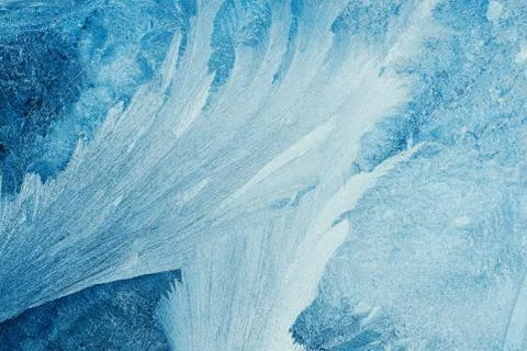 Frosty pattern on the window, winter abstract blue background Stock Photos