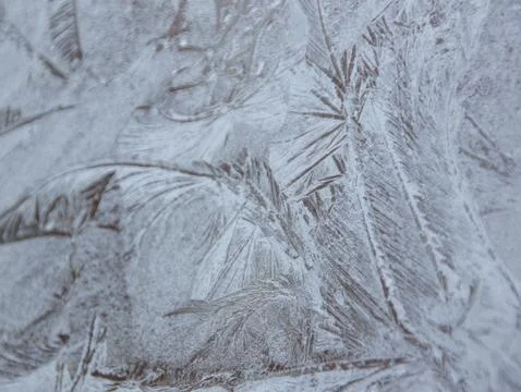 Frosty patterns on the window, close-up. Beautiful frosty background, from pa Stock Photos