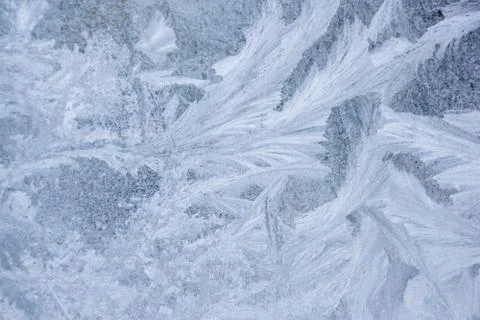 Frosty patterns on the window, close-up. Beautiful frosty background, from pa Stock Photos