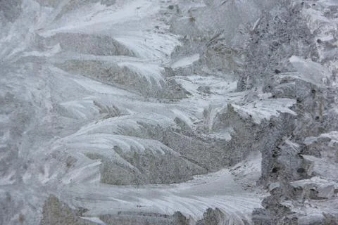 Frosty patterns on the window, close-up. Beautiful frosty background, from pa Stock Photos