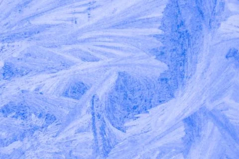 Frosty patterns on the window, close-up. Beautiful frosty background, from pa Stock Photos
