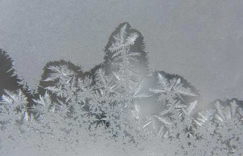 Frosty patterns on the window glass closeup. natural textures and backgrounds Stock Photos