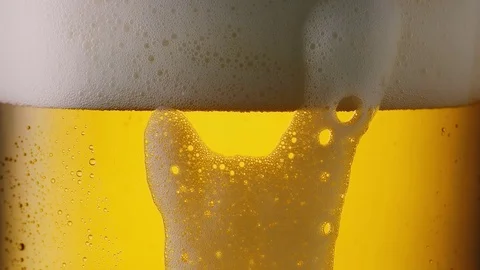 Froth sliding down of a cold beer glass with dew, 4k Stock Footage 79682183