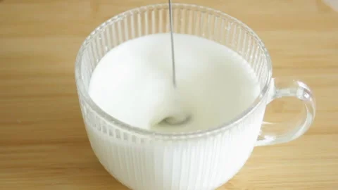 Frothing milk for coffee. Making perfect foam with an electric milk frother Stock Footage 315178425