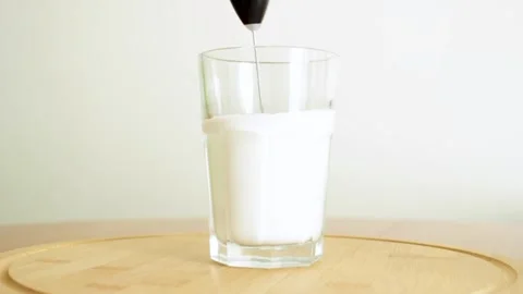 Frothing milk for coffee. Making the perfect foam with an electric milk frother. Stock Footage 315180059