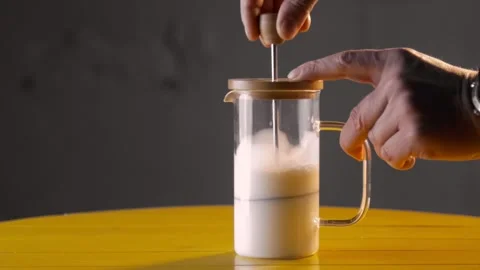 Frothing milk using French press Vídeos de archivo 143663064