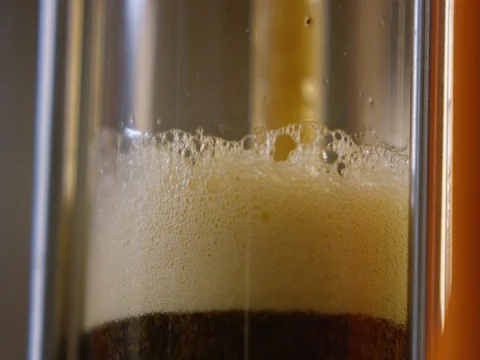 Frothy beer being filled into a glass 库存影片 83185762