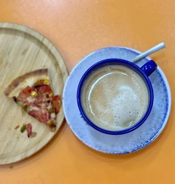 Frothy Coffee Cup and Pizza Slice Stock-Fotos