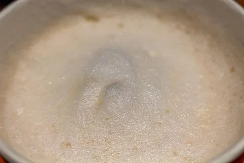 Frothy coffee foam with small bubbles in a white ceramic cup Stock Photos