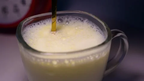 Frothy milk in a glass mug with a straw, Close-up view of a glass mug fille.. Stock Footage 321937053