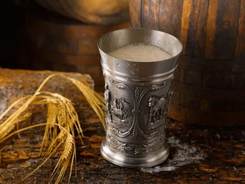 Frothy mug of beer set in a rustic cellar Stock Photos