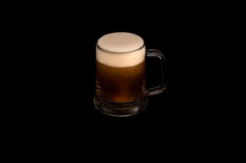 Frothy Mug of Dark Beer on Black Background Stock Photos