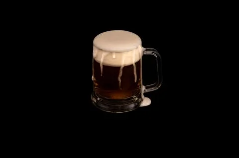 Frothy Mug of Dark Beer on Black Background Stock Photos
