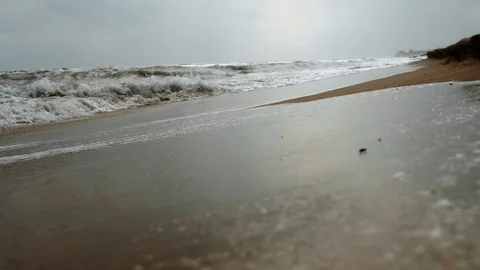 Frothy wave covers wet sand Stock Footage 107985648