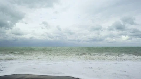 Frothy wave rolls up a pebble beach Stock-Footage 82312425