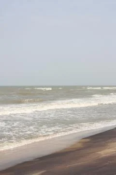 Frothy waves on beach with patterns Foto stock