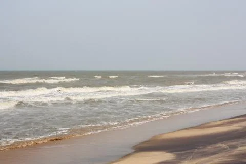 Frothy waves on beach with patterns Stock Photos